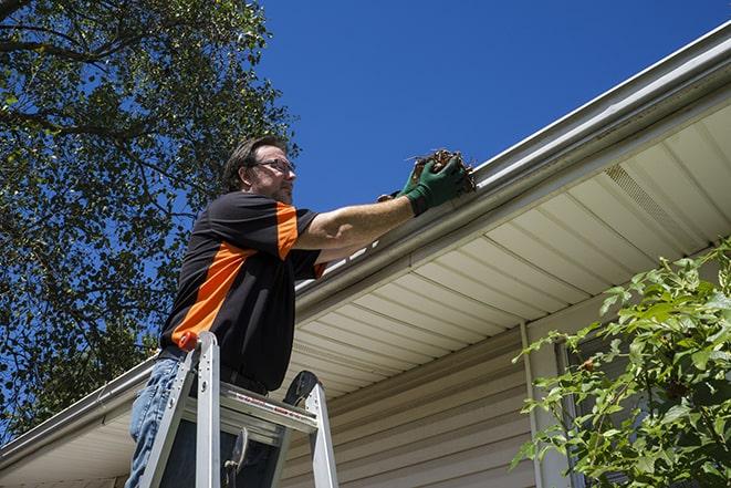 man installing new gutter system on a roof in Bannockburn, IL